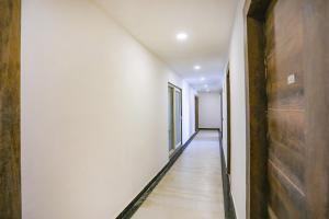 諾伊達的住宿－FabExpress F9 Noida Sector 27，空的走廊设有白色的墙壁和木地板