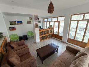 a living room with two couches and a table at The Stone Palace Turtuk in Nubra