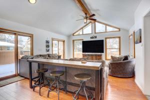 a kitchen and living room with a bar with stools at Denver Home with Game Room, 11 Mi to Downtown! in Centennial