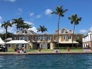 una casa grande con palmeras frente al agua en Copper and Lumber Store Hotel, en English Harbour Town