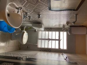 baño con lavabo y aseo y ventana en Flagship Jbs Eco Stay, en Kāziranga