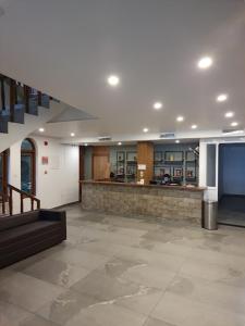 a lobby of a building with a counter and stairs at Hotel Omkara in Kozhikode
