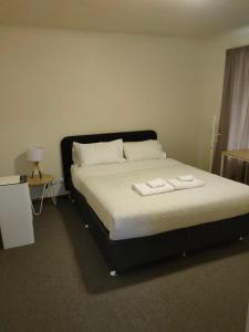 - une chambre avec un lit et 2 serviettes dans l'établissement DingDing upst-airs yellow House Free parking, à Sandy Bay
