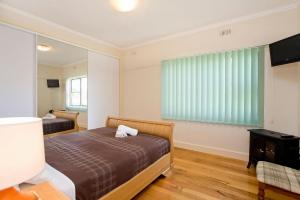 a bedroom with two beds and a flat screen tv at Bella Vista in Apollo Bay