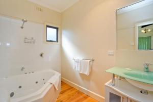 a white bathroom with a tub and a sink at Bella Vista in Apollo Bay