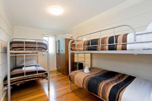 two bunk beds in a small room with wooden floors at Bella Vista in Apollo Bay