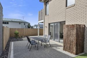 a patio with a table and chairs next to a building at Glas in Apollo Bay