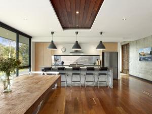 a kitchen with a wooden table and some chairs at Cypress Hill in Apollo Bay