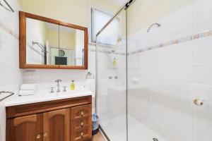 a bathroom with a shower and a sink and a mirror at Cara in Wye River