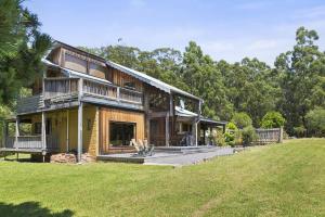 a large house with a deck and a yard at Walshan House in Apollo Bay