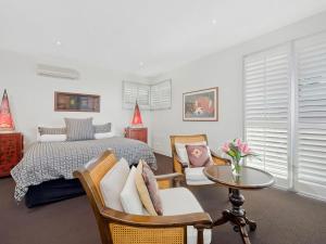 a bedroom with a bed and a table and chairs at Louvres in Wye River