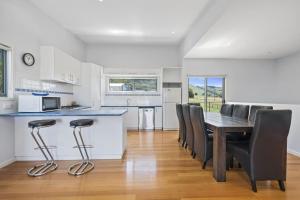 a kitchen and dining room with a table and chairs at Poseidon in Apollo Bay