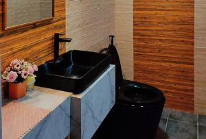 a bathroom with a black sink and a toilet at RedDoorz @ Dolce Cabanas Beach Resort in Zambales