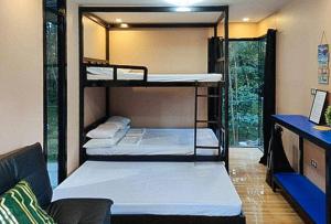 a room with three bunk beds in it at RedDoorz @ Dolce Cabanas Beach Resort in Zambales