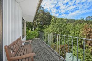 a wooden bench sitting on a balcony with a view at At Riverside in Wye River