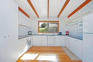 a kitchen with white cabinets and a window at At Riverside in Wye River