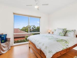 a bedroom with a bed and a large window at Bimbadeen in Apollo Bay