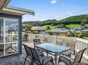 a patio with a table and chairs on a deck at Bimbadeen in Apollo Bay