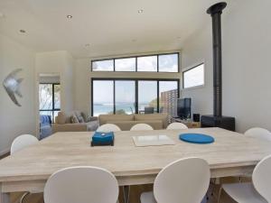 a dining room with a large wooden table and white chairs at Earth Sea Sky in Wye River