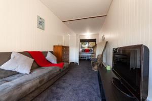 uma sala de estar com um sofá e uma televisão em The Albatross em Port Campbell