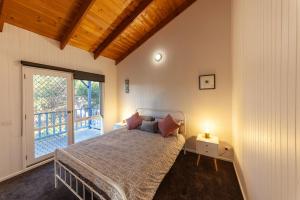 1 dormitorio con cama y ventana grande en The Albatross, en Port Campbell
