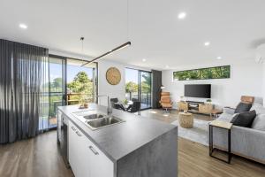 a kitchen and living room with a sink and a couch at Scenic Estate in Apollo Bay