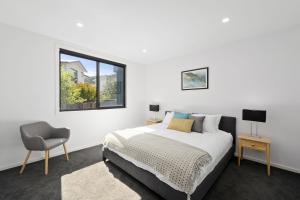 een slaapkamer met een bed, een stoel en een raam bij Scenic Estate in Apollo Bay