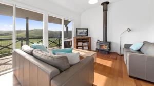 a living room with a couch and a fireplace at Rivernook in Johanna