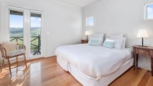 Un dormitorio blanco con una cama grande y una ventana. en Rivernook, en Johanna 4 fotos más