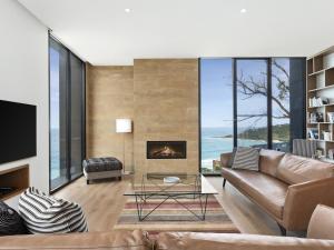 a living room with a couch and a fireplace at Iluka Blue in Wye River