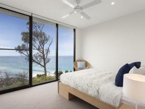 a bedroom with a view of the ocean at Iluka Blue in Wye River