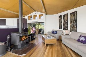 a living room with a couch and a fireplace at Manta Ray One in Apollo Bay