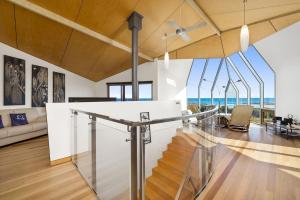 a glass staircase in a house with a view of the ocean at Manta Ray One in Apollo Bay