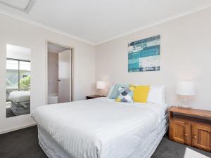 ein weißes Schlafzimmer mit einem großen Bett und einem Fenster in der Unterkunft Coral Reef in Marengo