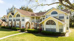 Una gran casa amarilla con un paisaje en Beautiful cozy Retreat near Disney - spacious condo, en Kissimmee