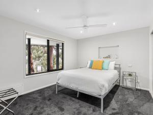 a white bedroom with a bed and a window at Gulah in Wye River