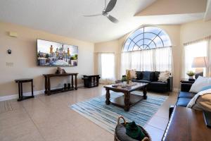 una sala de estar con un sofá y una mesa en Beautiful cozy Retreat near Disney - spacious condo, en Kissimmee