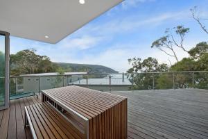 a deck with a bench on top of a house at Coastal Break in Wye River
