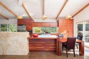 a kitchen with wooden cabinets and a table with chairs at Eagle Ridge in Hordern Vale