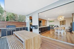 an open kitchen and living room with a large window at Coastal Break in Wye River