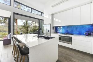 a kitchen with white cabinets and a large window at Phoenix on Wye in Wye River