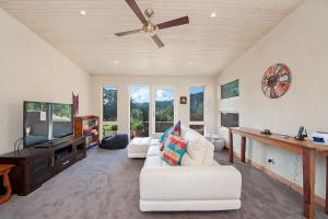 a living room with a white couch and a ceiling fan at Eagle Ridge in Hordern Vale