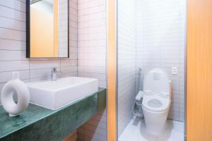 La salle de bains est pourvue d'un lavabo et de toilettes. dans l'établissement Grandma Lu Saigon Hostel - Japan Town, à Hô-Chi-Minh-Ville