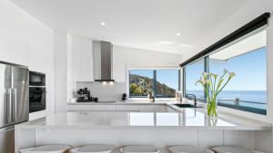 a white kitchen with a view of the ocean at The Blue House in Wye River