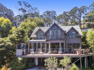 a house on a dock with chairs and trees at A Wye's Choice in Wye River