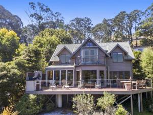 a house on a dock with chairs and trees at A Wye s Choice in Wye River