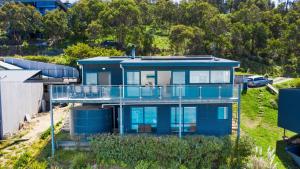 a blue house with a balcony on a hill at The Blue House in Wye River