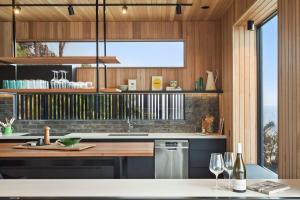 a kitchen with wooden walls and a large window at At Wye Eyrie II in Wye River