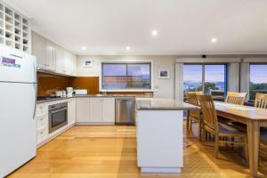 a kitchen with a table and a dining room at Sound Of The Sea in Apollo Bay