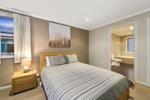 a bedroom with a bed and a bathroom at Sound Of The Sea in Apollo Bay